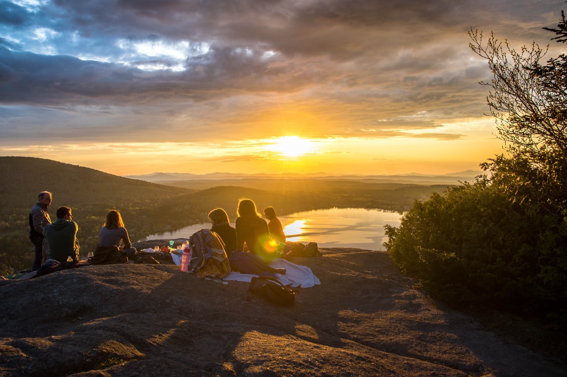 group on top of a mountain watching the sun set_how to plan a corporate retreat_flok