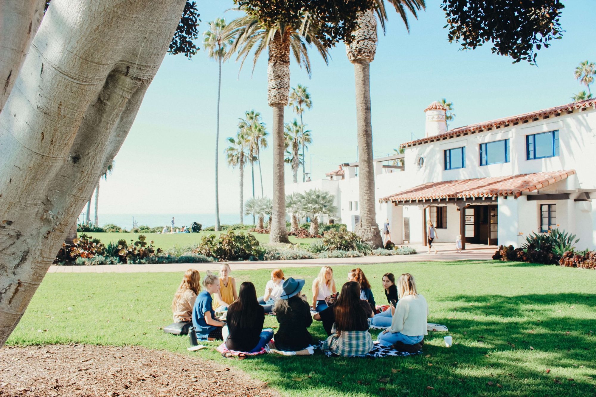 group sitting in a circle on the grass_team building activities for work_flok