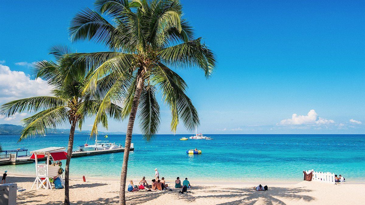 clear water with boat floating near beach_best corporate retreat destinations_flok